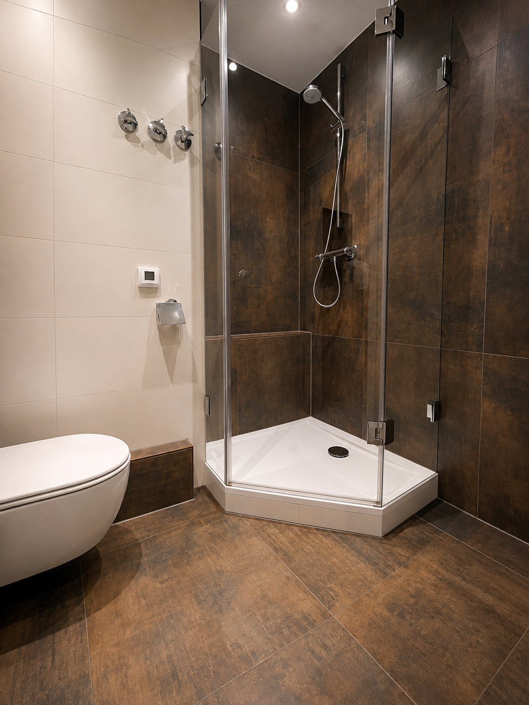Eckdusche mit Glaswänden und dunklen Fliesen in Rostoptik, im Vordergrund ein wandhängendes WC auf Bodenfliesen in Holzoptik