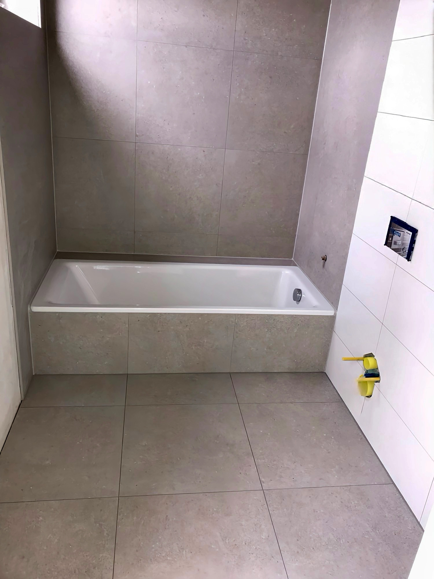 Badsanierung mit neu gefliester Badewannenverkleidung im Rohbauzustand
